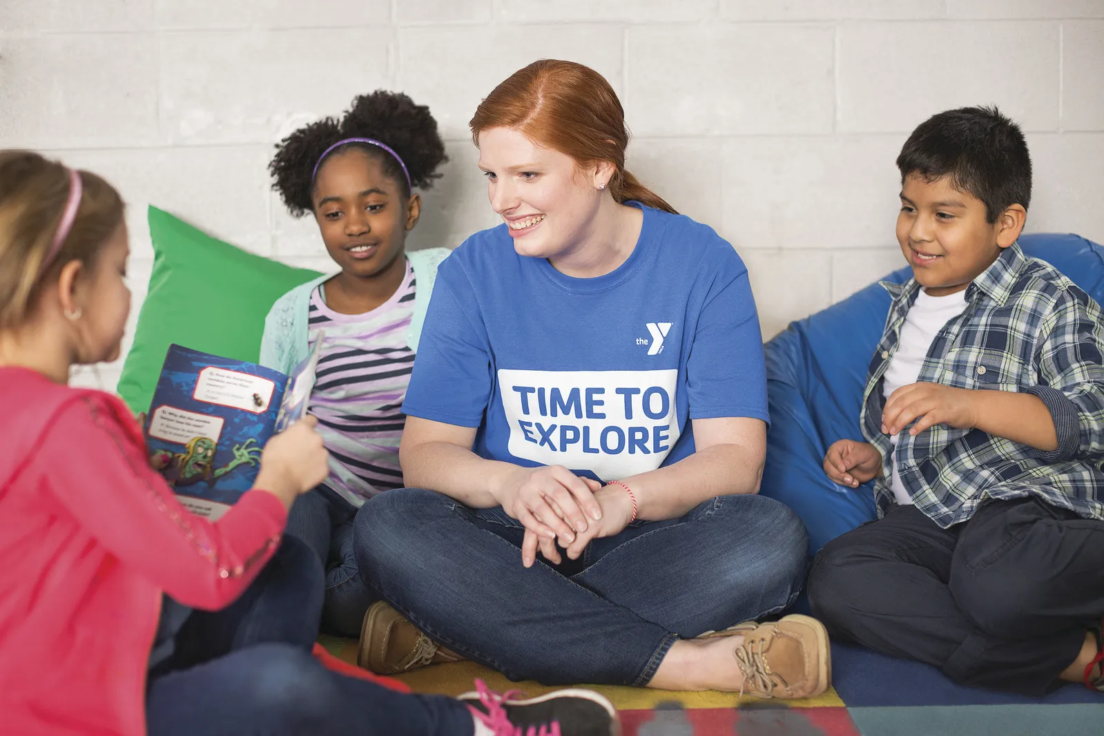 Afterschool staff sitting with a group of kids