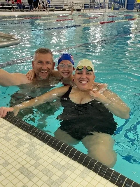 A couple with a young kid in the pool